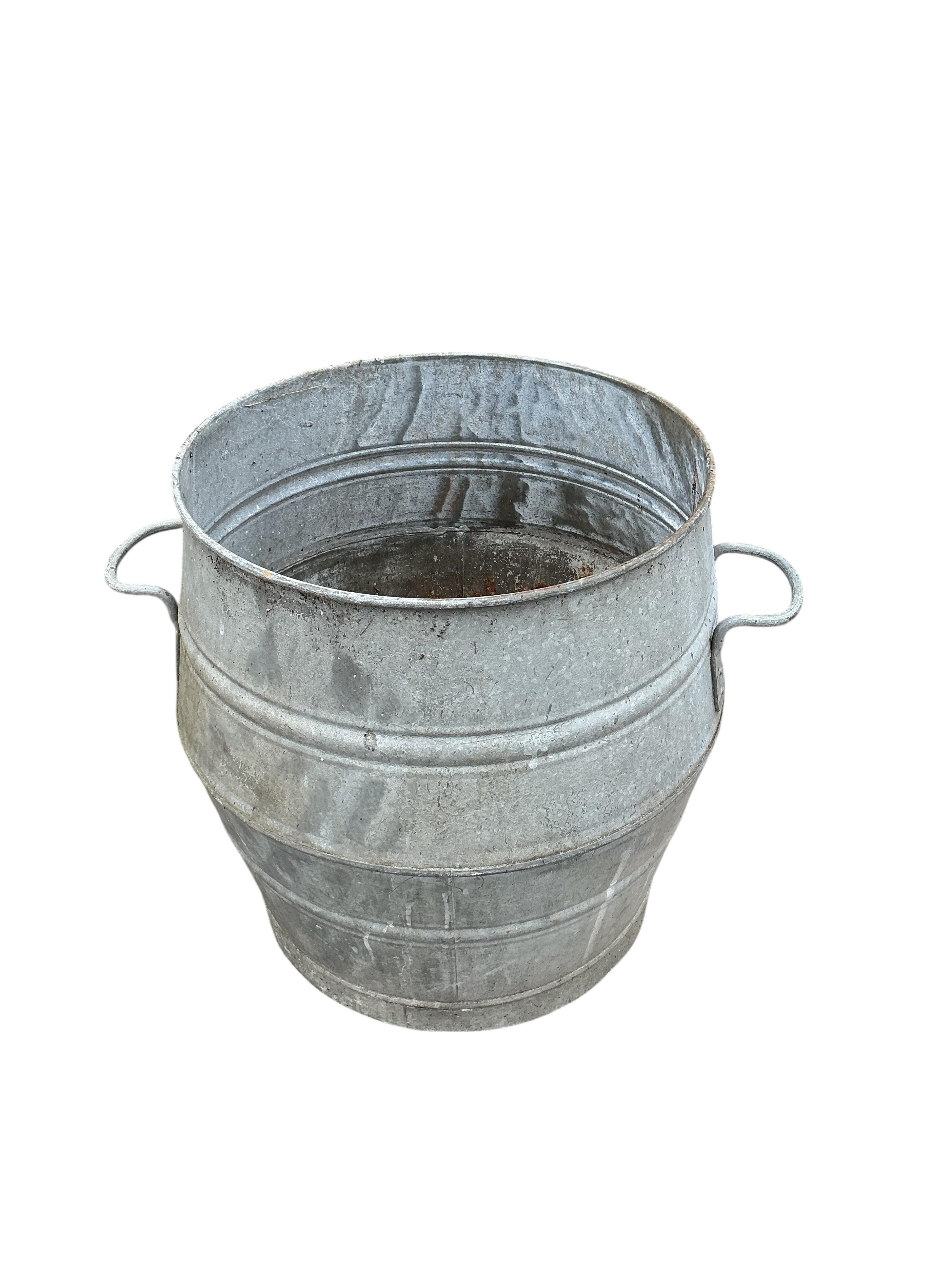 A near pair of circular galvanised metal barrels, diameter 46cm, height 52cm